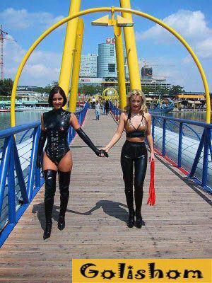 Девушки гуляют по мосту в интерестных костюмах